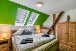 a bedroom with a green accent wall and a bed at Ferienhof am See in Alt Zeschdorf