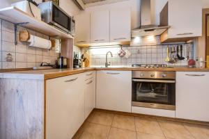 a kitchen with white cabinets and a sink at Apartment Sonnenschein in Mühlbach +17 photos