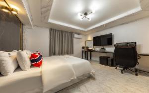 a hotel room with a bed and a television at Iksan Hotel G7 in Songman