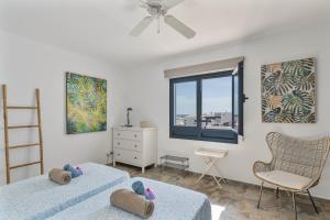 a bedroom with two beds and a chair and a window at Casa Bidasoa 35 in Playa Blanca +21 photos