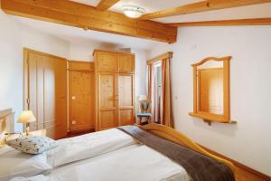 ein Schlafzimmer mit einem großen Bett und einem Spiegel in der Unterkunft Maierhof in Wengen