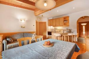 eine Küche und ein Wohnzimmer mit einem Tisch und einem Sofa in der Unterkunft Maierhof in Wengen
