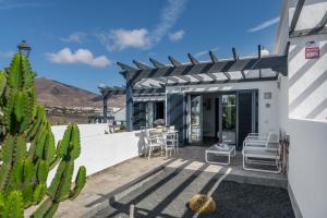 a patio of a house with a table and chairs at Casa Bidasoa 35 in Playa Blanca