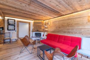 a living room with a red couch and chairs at Le régina in Megève +14 photos