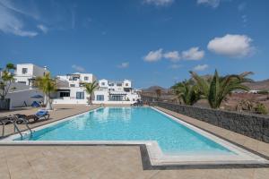 a swimming pool in a resort with houses in the background at Casa Bidasoa 35 in Playa Blanca