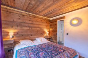 a bedroom with a bed in a wooden wall at Le régina in Megève