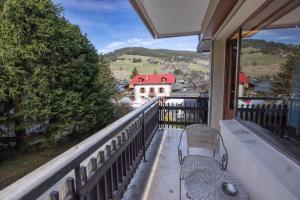 a balcony with a bench and a view of a house at Le régina in Megève