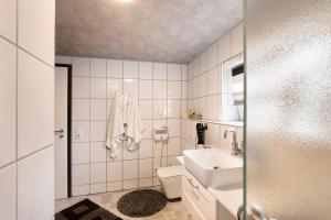 a white bathroom with a sink and a toilet at Ferienwohnung am Wartberg in Herbrechtingen +15 photos