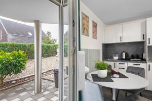 a kitchen with a white table and a patio at Ferienwohnung am Wartberg in Herbrechtingen