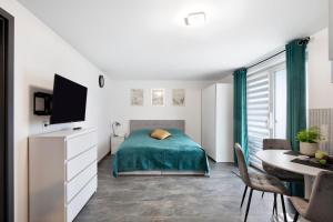 a bedroom with a bed and a table and a tv at Ferienwohnung am Wartberg in Herbrechtingen