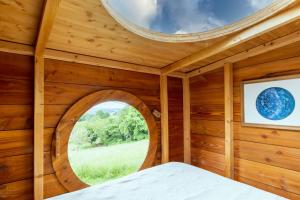 a wooden room with a round window in a log cabin at Cabane aux étoiles in Auriac-du-Périgord