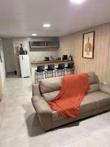 a living room with a couch and a kitchen at Mini Casa Privativa -Praia do Tombo in Guarujá +13 photos
