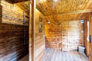 a wooden bathroom with a shower and a ladder at Cabane aux étoiles in Auriac-du-Périgord