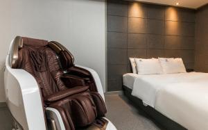 a hotel room with a chair and a bed at Iksan Hotel G7 in Songman