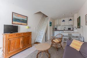 a living room with a couch and a tv and a kitchen at La Forestière Cap Ferret - Réf 2 in Lège-Cap-Ferret
