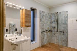a bathroom with a sink and a shower at Ferienhäuser im Sternenpark am See in Lochow +39 photos