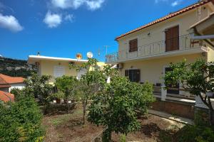 a white house with trees in front of it at Captain Spiros Paxoi in Gaios