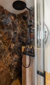 a shower in a bathroom with a stone wall at Ocean View Apartments in Caniço +48 photos