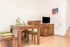 a room with a wooden table and chairs and a television at Moserhof Ferienwohnung Sunnseit in Sarntal