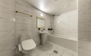 a bathroom with a toilet and a sink and a tub at Iksan Hotel G7 in Songman +19 photos
