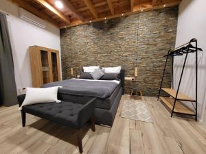 a bedroom with a bed and a chair and a brick wall at Hainberg-Loft mit Gartensauna in Mellrichstadt