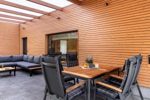 a patio with a table and chairs and a couch at Ferienhäuser im Sternenpark am See in Lochow