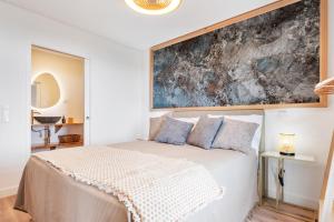 a bedroom with a bed with a large painting on the wall at Ocean View Apartments in Caniço
