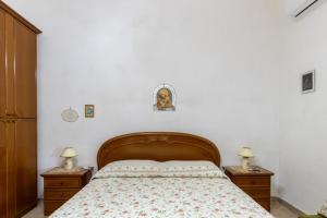 a bedroom with a bed with two nightstands and two lamps at Sartiglia Domu in Oristano