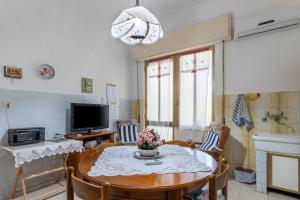 a living room with a table and a television at Sartiglia Domu in Oristano