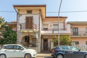 two cars parked in front of a house at Sartiglia Domu in Oristano