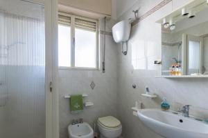 a white bathroom with a sink and a toilet at Sartiglia Domu in Oristano +12 photos