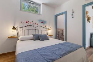 a bedroom with a large bed with blue pillows at Trulli House in Putignano