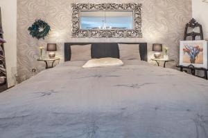 a bedroom with a large bed with a mirror on the wall at Pension Schlachter's Hius in Algermissen