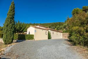a driveway with a building and a tree at La Vue des Anges in Draguignan