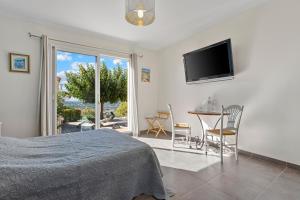 a bedroom with a bed and a table and a television at La Vue des Anges in Draguignan