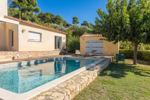 a swimming pool in a yard next to a house at La Vue des Anges in Draguignan +13 photos