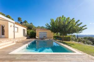 a villa with a swimming pool in front of a house at La Vue des Anges in Draguignan