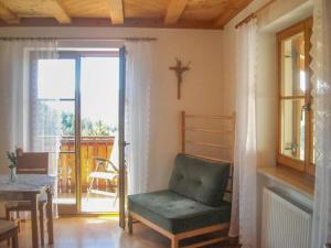 a living room with a chair and a table and a window at Gmosnhof Mölten in Meltina
