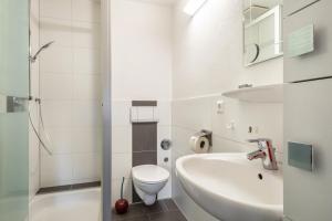 a white bathroom with a toilet and a sink at Obsthof Mainberger in Kressbronn am Bodensee +41 photos