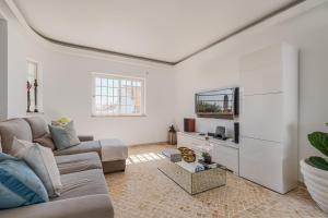 a living room with a couch and a tv at Casa do Rei - Charneca in Charneca