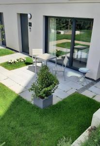 a patio with a table and chairs in the grass at Bude 23 - Ferienwohnung Aalen in Aalen
