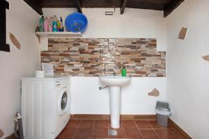 a bathroom with a sink and a washing machine at Casa Majos in Tesejerague +22 photos