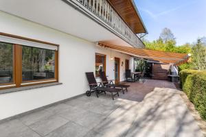 a patio with chairs and a patio umbrella at Haus Sonnenblick in Diemelsee