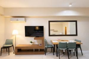 a dining room with a table and chairs and a mirror at Nade Suites - Pico De Loro MIB 601 in Nasugbu