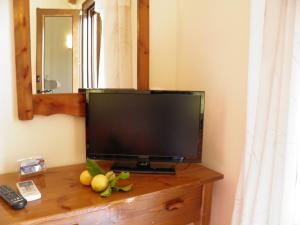 a flat screen tv sitting on top of a wooden dresser at Captain Spiros Paxoi in Gaios