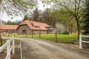 a house on a dirt road next to a fence at Suite Südterrasse mit Loftcharm in Dedelstorf