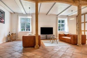 a living room with a couch and a flat screen tv at Suite Südterrasse mit Loftcharm in Dedelstorf