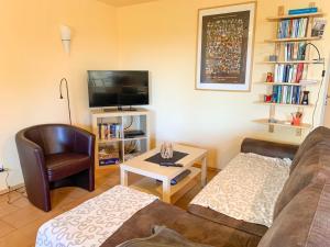 a living room with a couch and a tv at Ferienwohnung Wadle in Gleisweiler