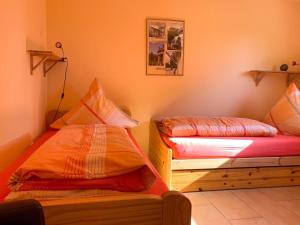 two beds in a room with orange walls at Ferienwohnung Wadle in Gleisweiler