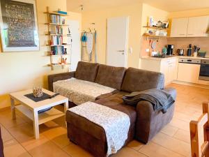 a living room with a brown couch and a table at Ferienwohnung Wadle in Gleisweiler +6 photos
